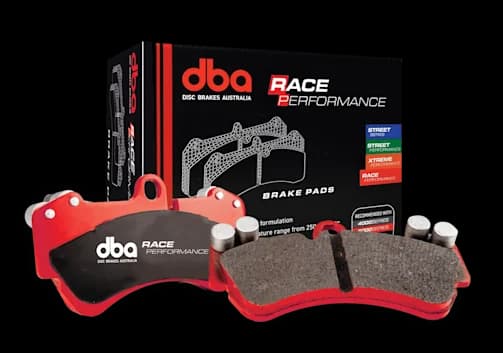 Pastillas de freno DBA Race Performance con placas de respaldo rojas y material de fricción especializado junto a su caja de embalaje