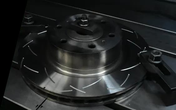 Disco de freno DBA fabricado con hierro fundido XG-150 mostrando patrón de superficie ranurada y superficie de montaje de buje de precisión