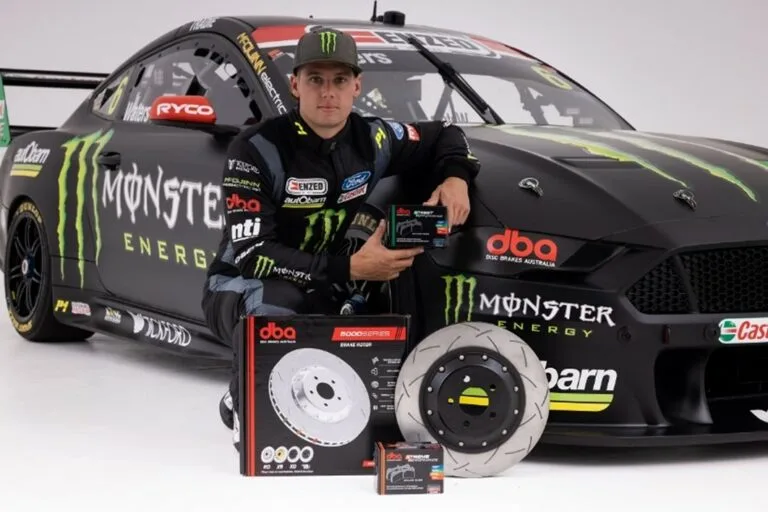 Asociación Productos de Freno DBA con Tickford Racing - Temporada Supercars 2022 Piloto Tickford Racing Supercars posando con productos discos de freno DBA frente a coche de carreras Ford Mustang Monster Energy durante anuncio asociación 2022